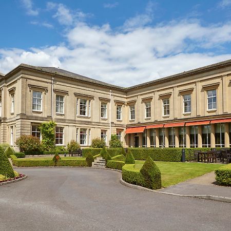 Macdonald Bath Spa Hotel Zewnętrze zdjęcie The photo depicts a large, elegant building with a classic architectural style, featuring a combination of stone and large windows. The structure appears to have two sections: a main, stately part on the left and an adjoining section that has a terra