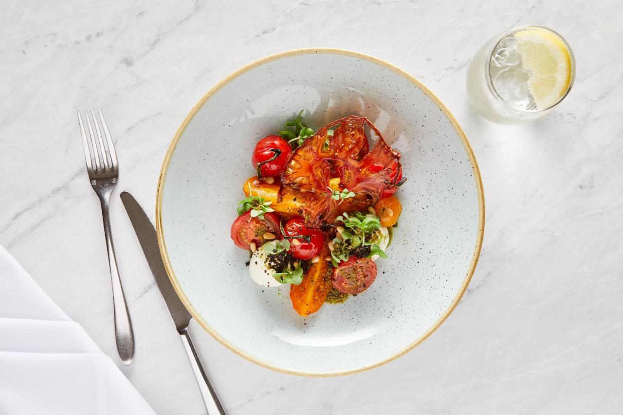 Macdonald Bath Spa Hotel Zewnętrze zdjęcie The photo shows a beautifully arranged plate of food. The dish features a mix of colorful ingredients, including roasted or grilled vegetables, likely bell peppers and tomatoes, along with fresh greens. There are also some circular slices of another 