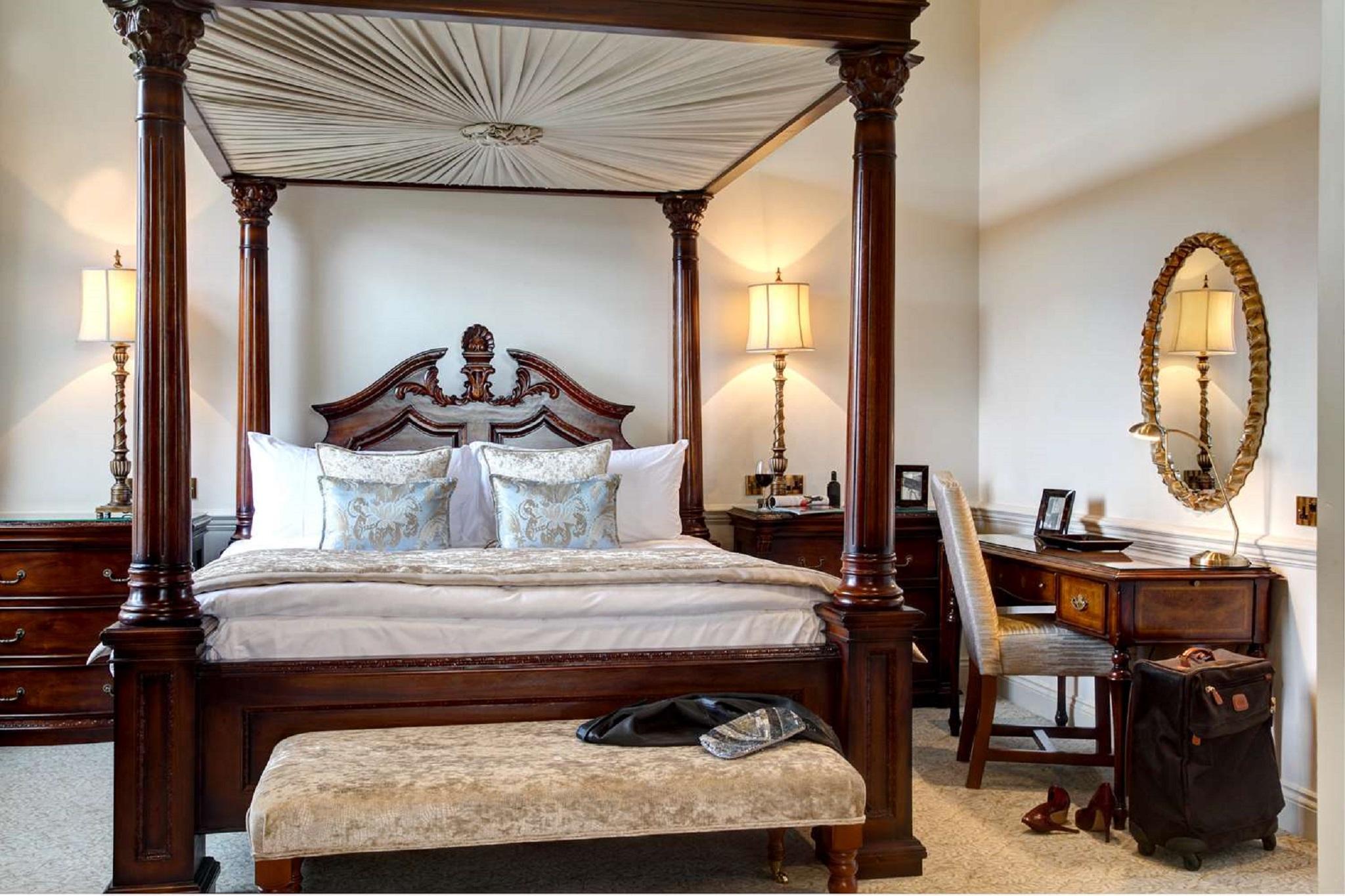 Macdonald Bath Spa Hotel Zewnętrze zdjęcie The photo showcases a beautifully designed bedroom featuring a four-poster canopy bed with intricate woodwork and elegant drapery. The bed is adorned with plush pillows and a decorative bedspread. On either side of the bed, there are stylish lamps il