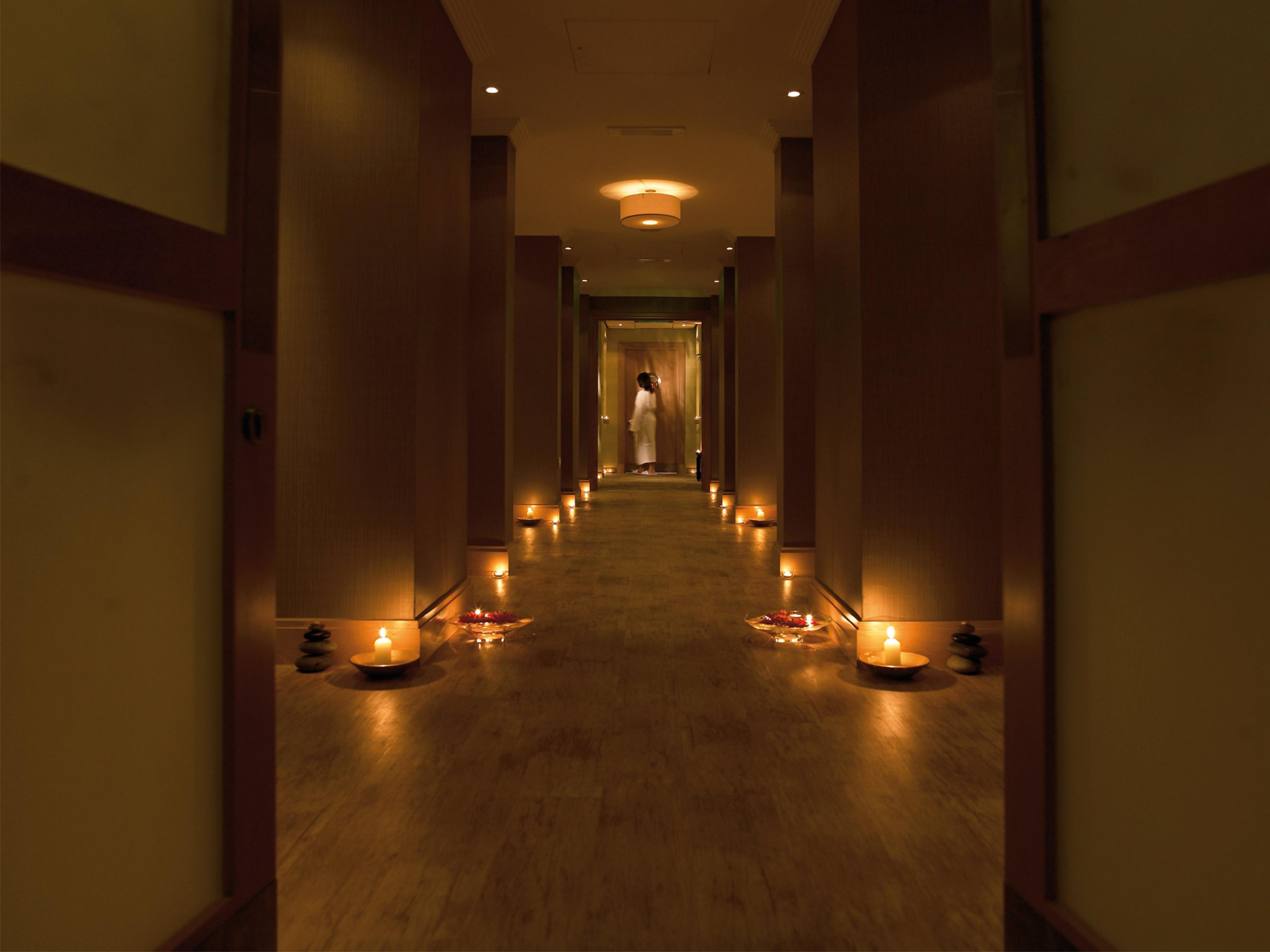 Macdonald Bath Spa Hotel Zewnętrze zdjęcie The photo shows a dimly lit corridor lined with soft lighting. On both sides of the hallway, small candles are placed in bowls, creating a warm and inviting ambiance. At the end of the corridor, there appears to be a person standing, possibly prepari