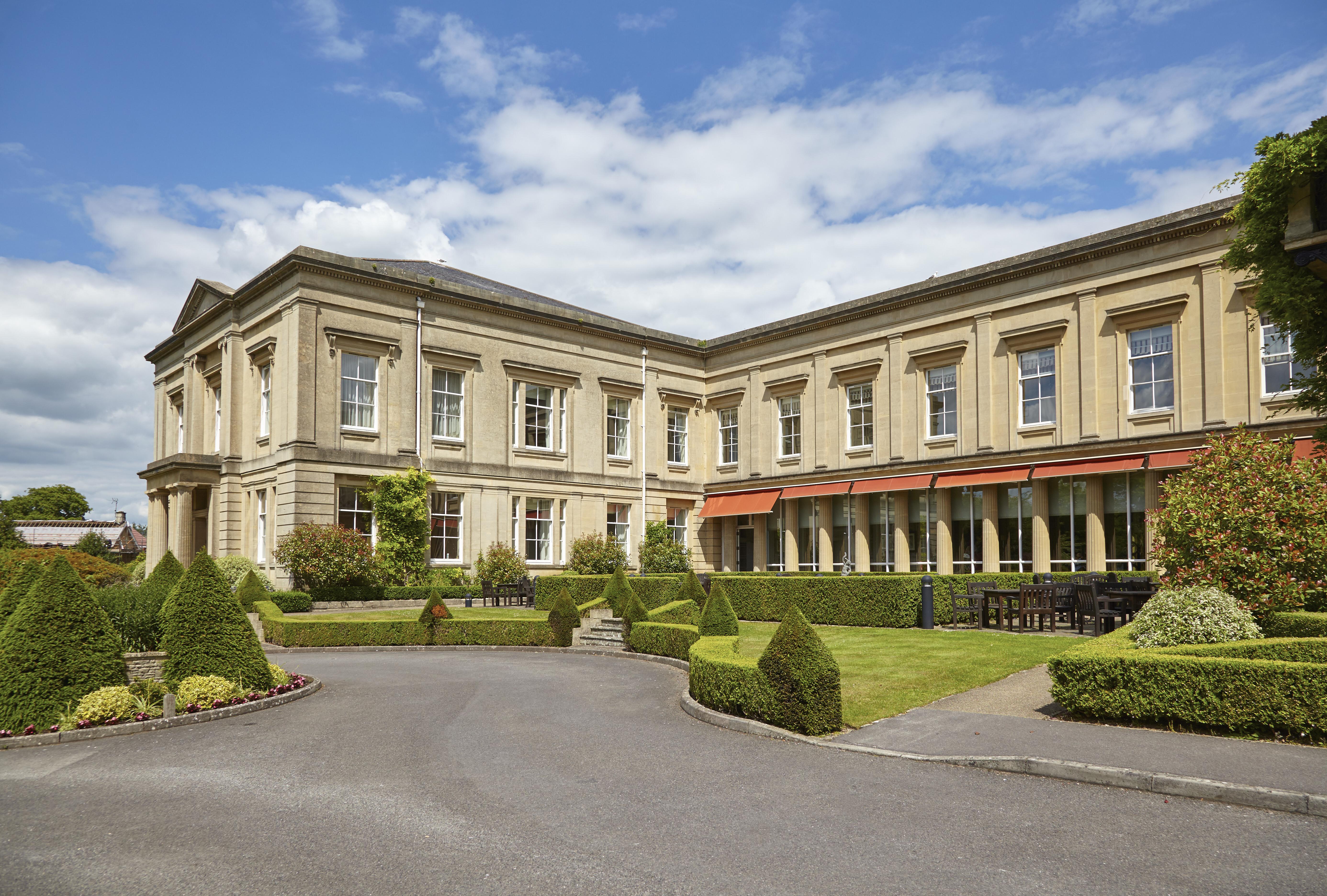 Macdonald Bath Spa Hotel Zewnętrze zdjęcie The photo depicts a large, elegant building with a classic architectural style, featuring a combination of stone and large windows. The structure appears to have two sections: a main, stately part on the left and an adjoining section that has a terra
