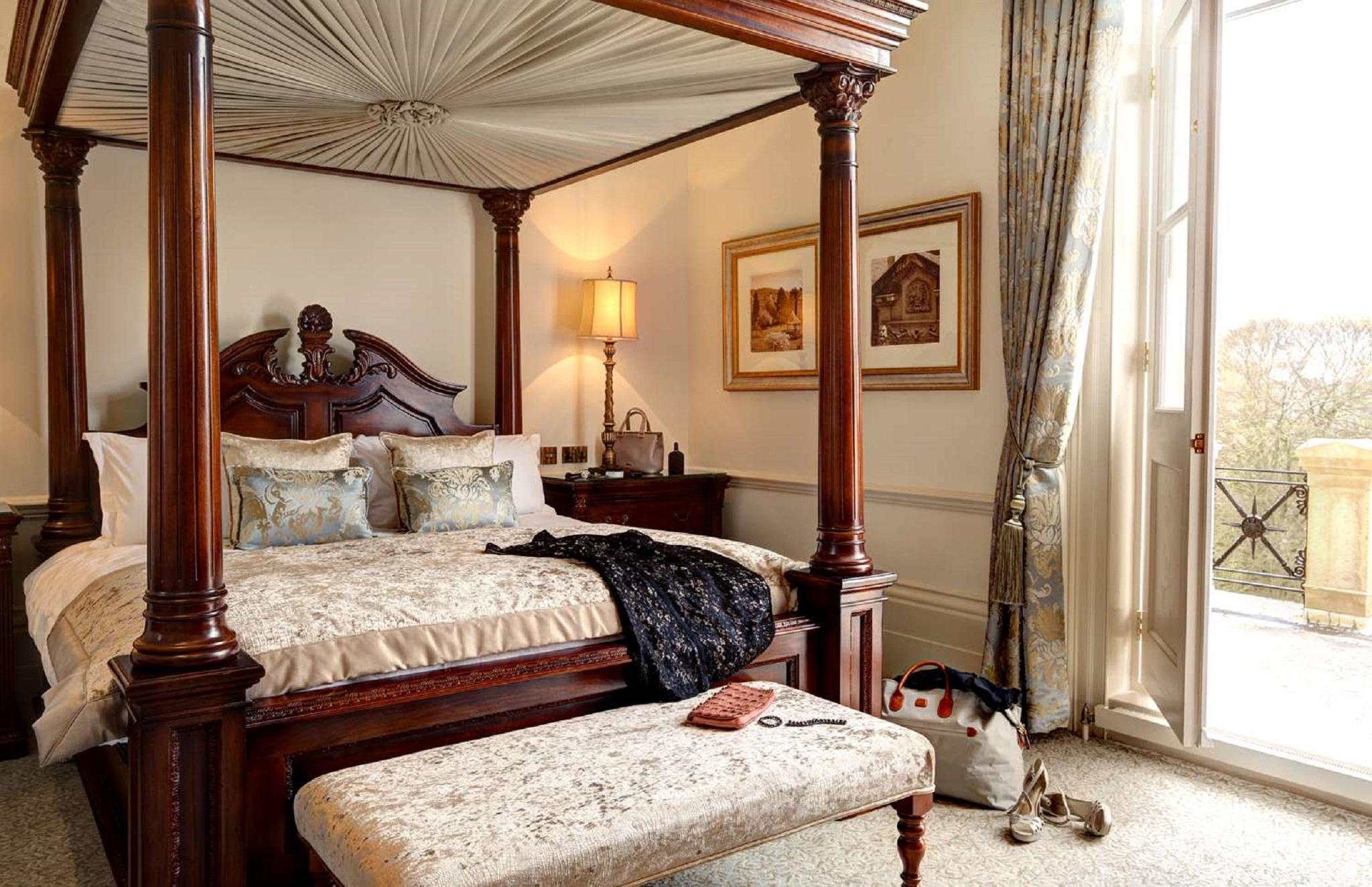 Macdonald Bath Spa Hotel Zewnętrze zdjęcie The photo depicts a beautifully designed bedroom featuring a four-poster bed with a decorative canopy. The bed is dressed with elegant bedding and several patterned pillows. Adjacent to the bed, there is a matching wooden nightstand with a stylish la