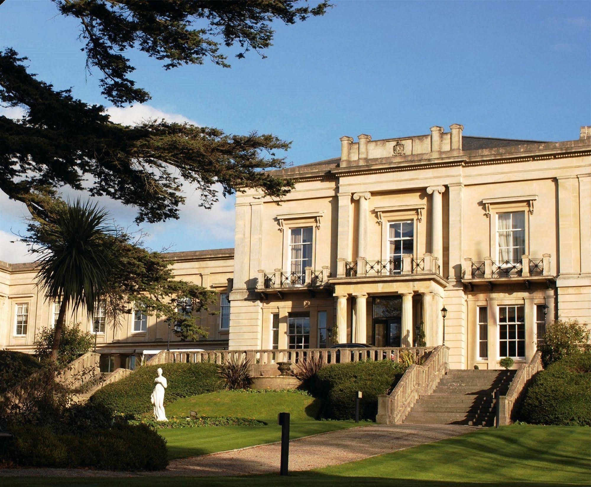 Macdonald Bath Spa Hotel Zewnętrze zdjęcie The photo shows an elegant building with classical architecture, featuring large windows and decorative elements. The facade is light-colored, and there are several balconies. In front of the building, there is a landscaped area with greenery, includ
